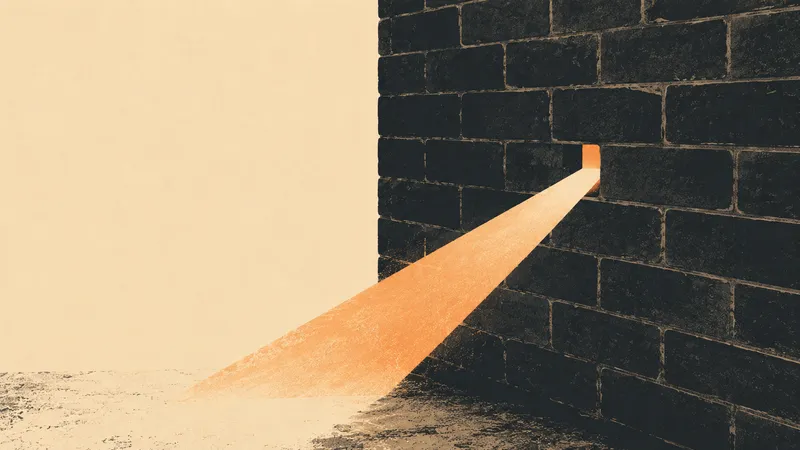 A bricked-up wall with a single brick removed, one warm beam of light streaming through the small gap