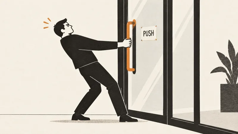 A person pulls a glass door handle beside a small PUSH sign.