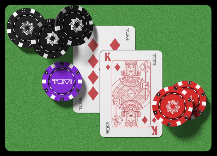 TUMI playing cards and branded poker chips arranged on green felt