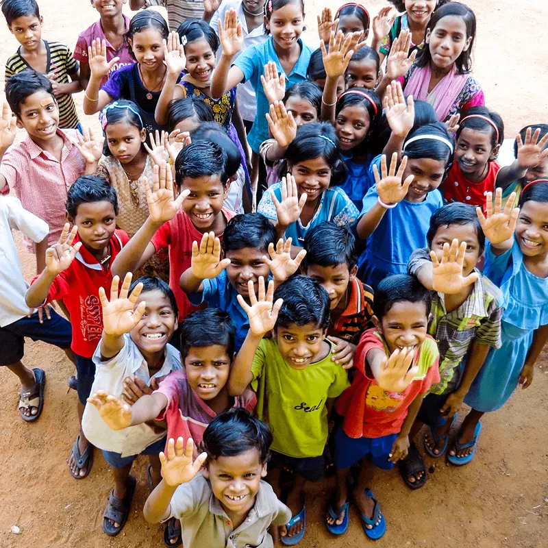 Children and fellowship volunteers waving at the camera