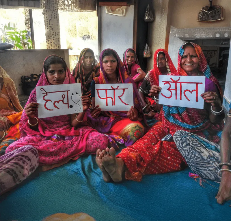 Women holding handwritten Help for All signs