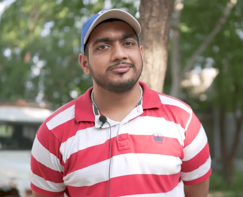 Fellow interview portrait: a man in a cap and striped shirt outdoors