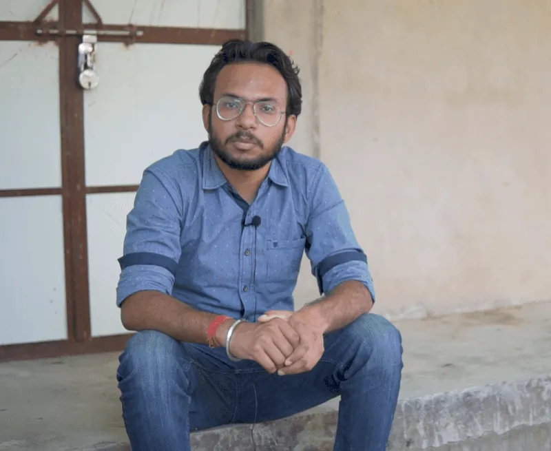 Fellow interview portrait: a man wearing glasses, seated indoors